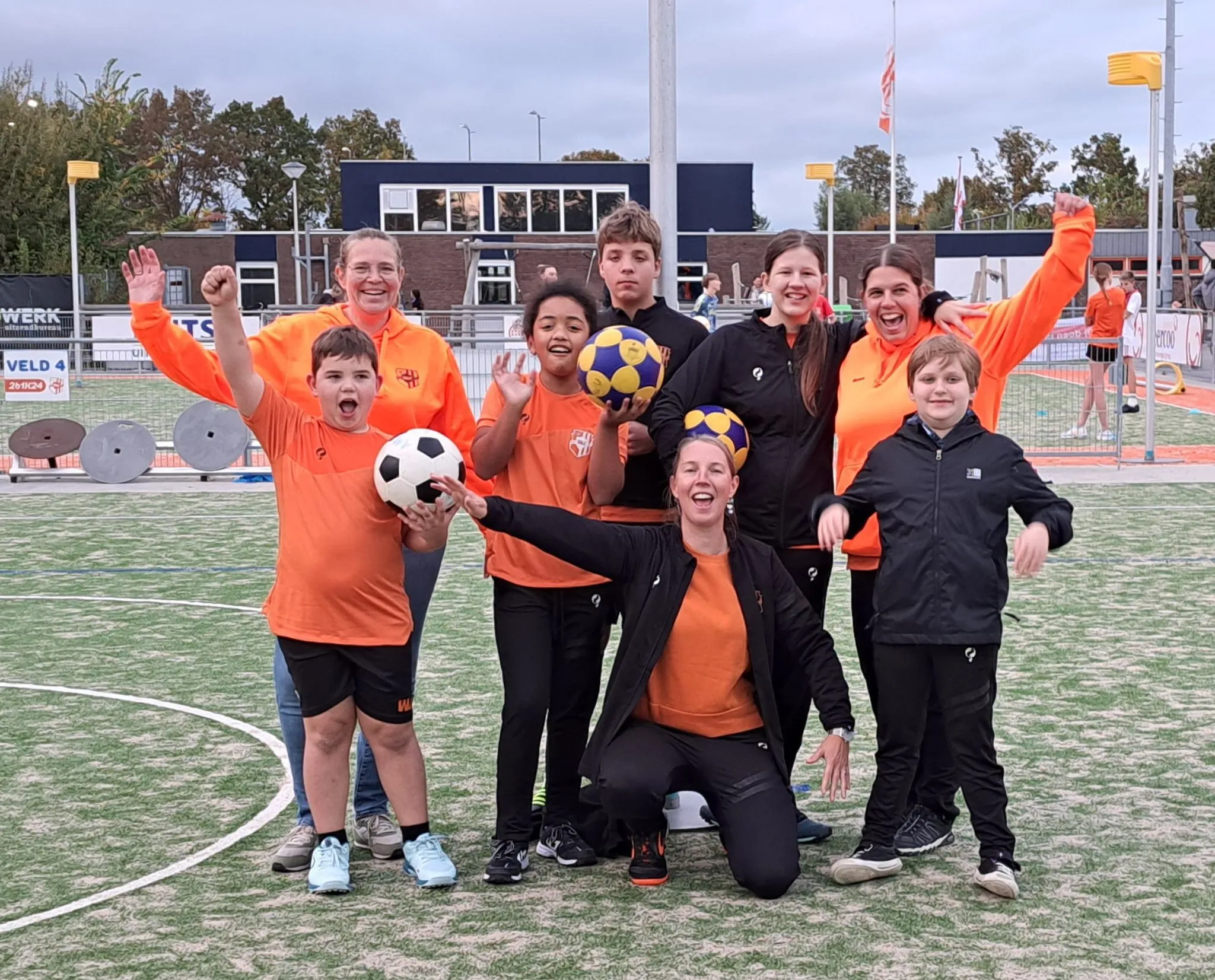 De Kanjers met hun trainers op het veld bij Merenveld